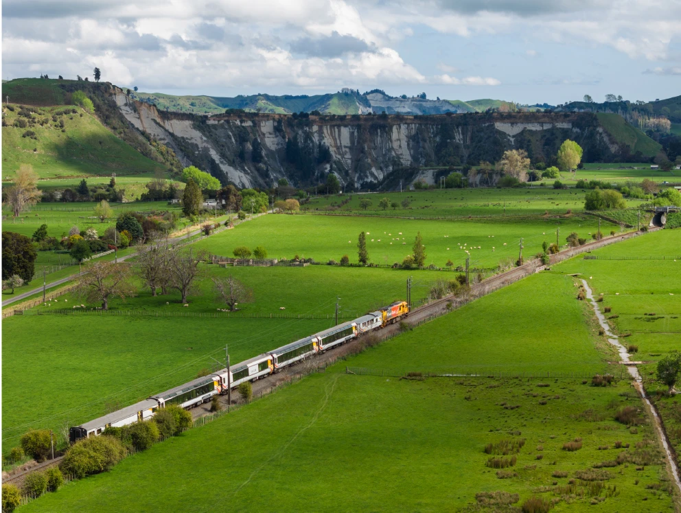 Aerial view of the Northern Explorer train travelling through classic NZ farmlands