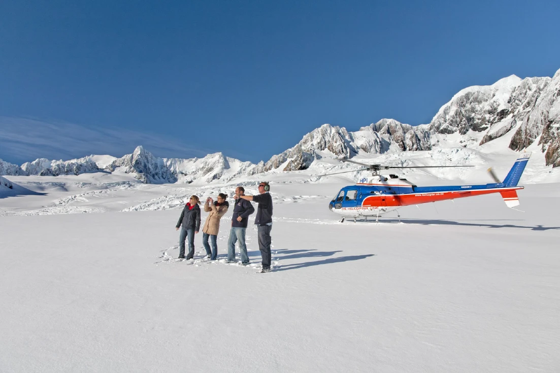 Group of people on helicopter tour standing on the Franz Josef glacier
