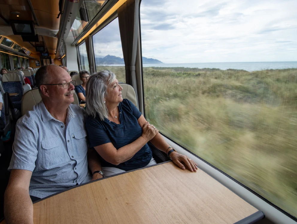 Couple enjoying the comfortable seating and large viewing windows onboard the Coastal Pacific