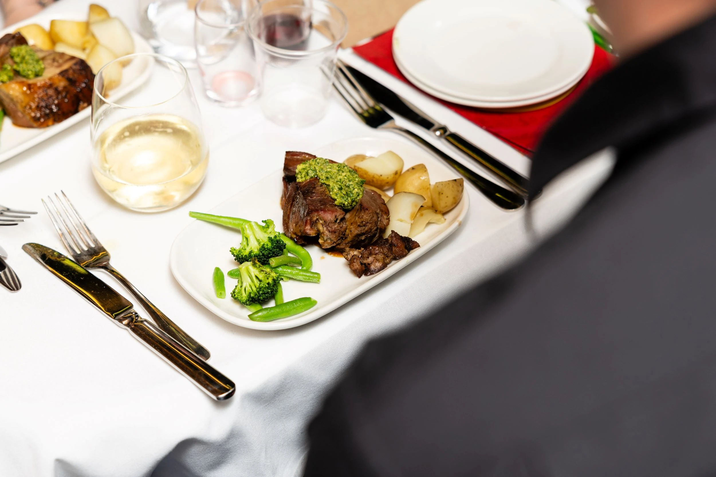 Chef's choice gourmet steak, vegetable and potato meal served on white table cloth table
