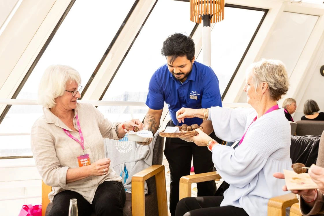 WOW passengers indulging in an assortment of canapés and a flute of bubbles