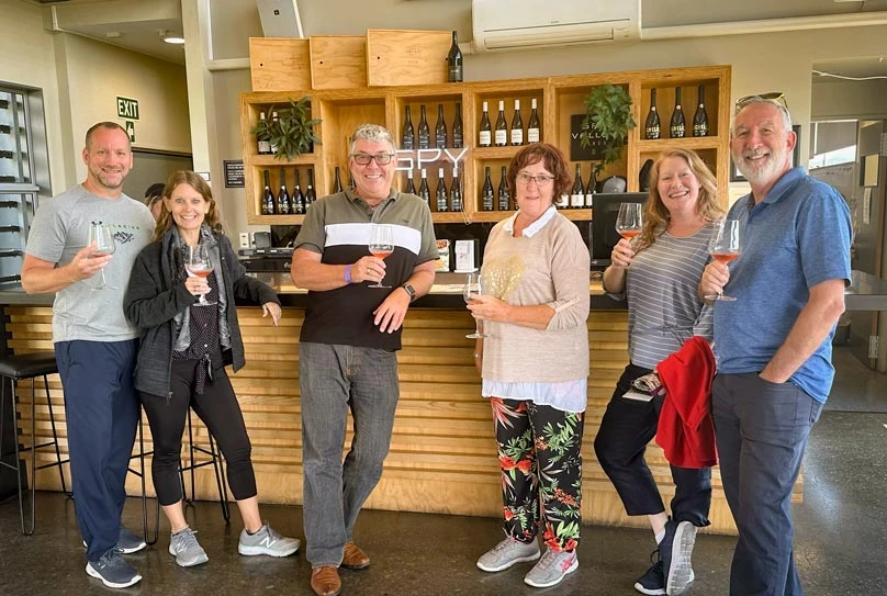 A group of happy travellers enjoying a wine tour