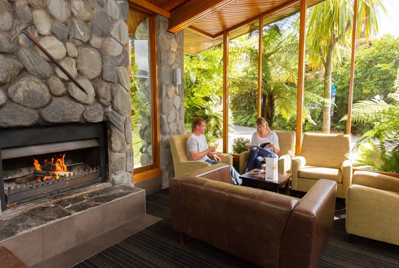 Couple relaxing in the Scenic Hotel Franz Josef Glacier Fireplace Lounge