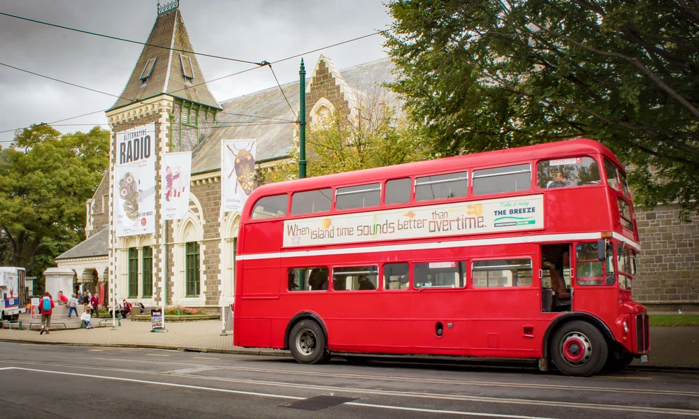 Red bus pulling up to the Canterbury Museum in Christchurch