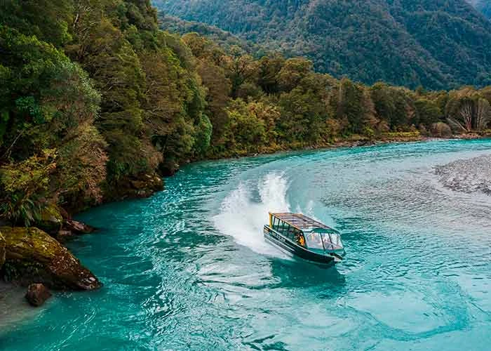 Boat speeding through Haast River making waves
