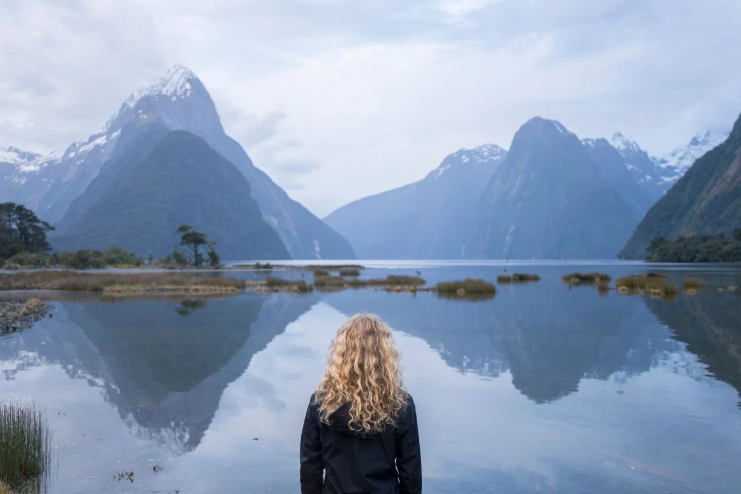 Woman looking over the mirror waters of Milford Sounds