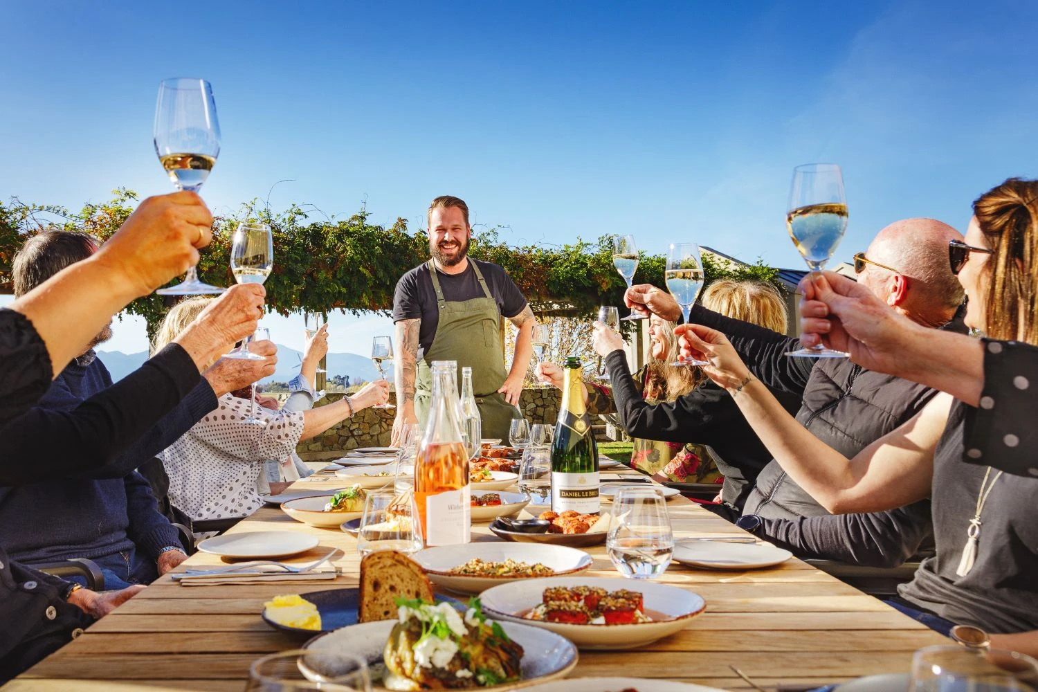Group of people enjoying wine and food in the sun in a Marlborough vineyard