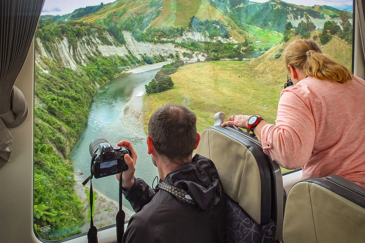 couple photographing a view of the Rangitikei Viaduct from the Northern Explorer train