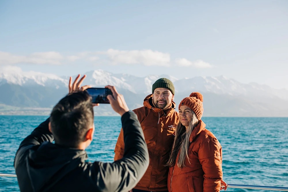 A couple standing in front of Kaikoura ocean and mountain views