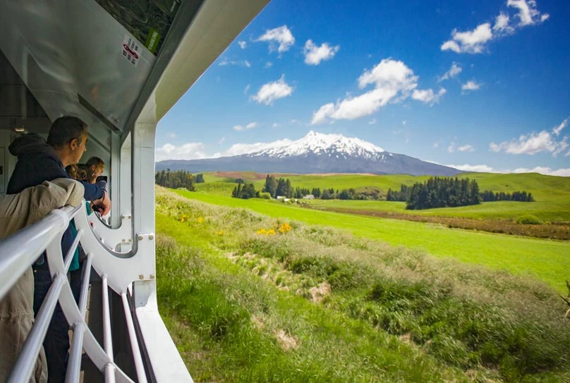 Northern Explorer approaching mt Ruapehu with a view from the open air viewing carriage