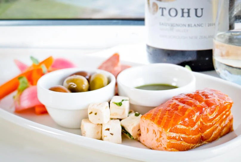 Salmon meal posed with a bottle of Sauvignon wine on a white table cloth
