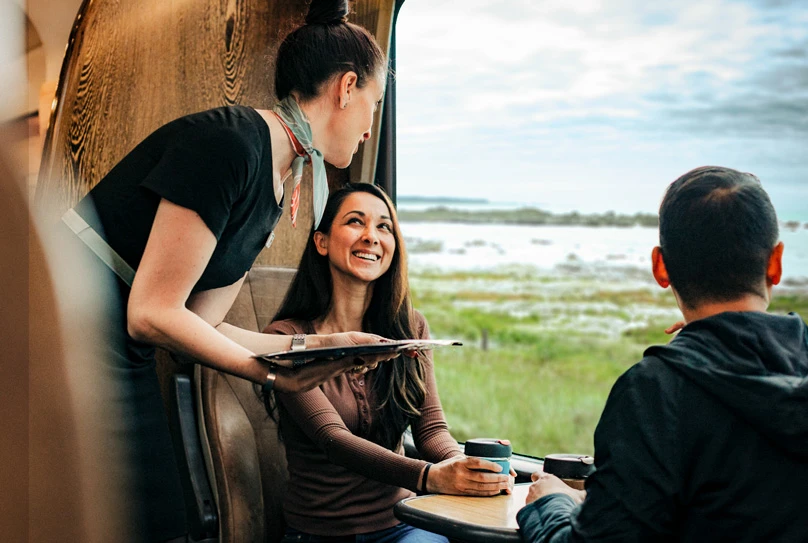 Couple being served in the Scenic Cafe onboard Great Journeys train